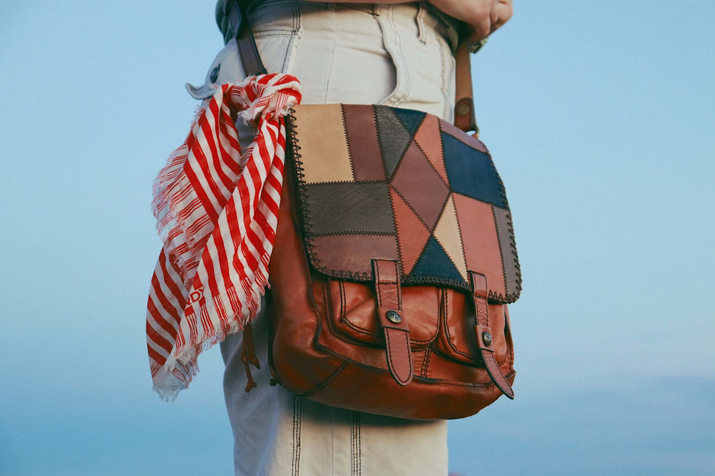 red and white striped frances bandana used as a scarf tie around a leather purse