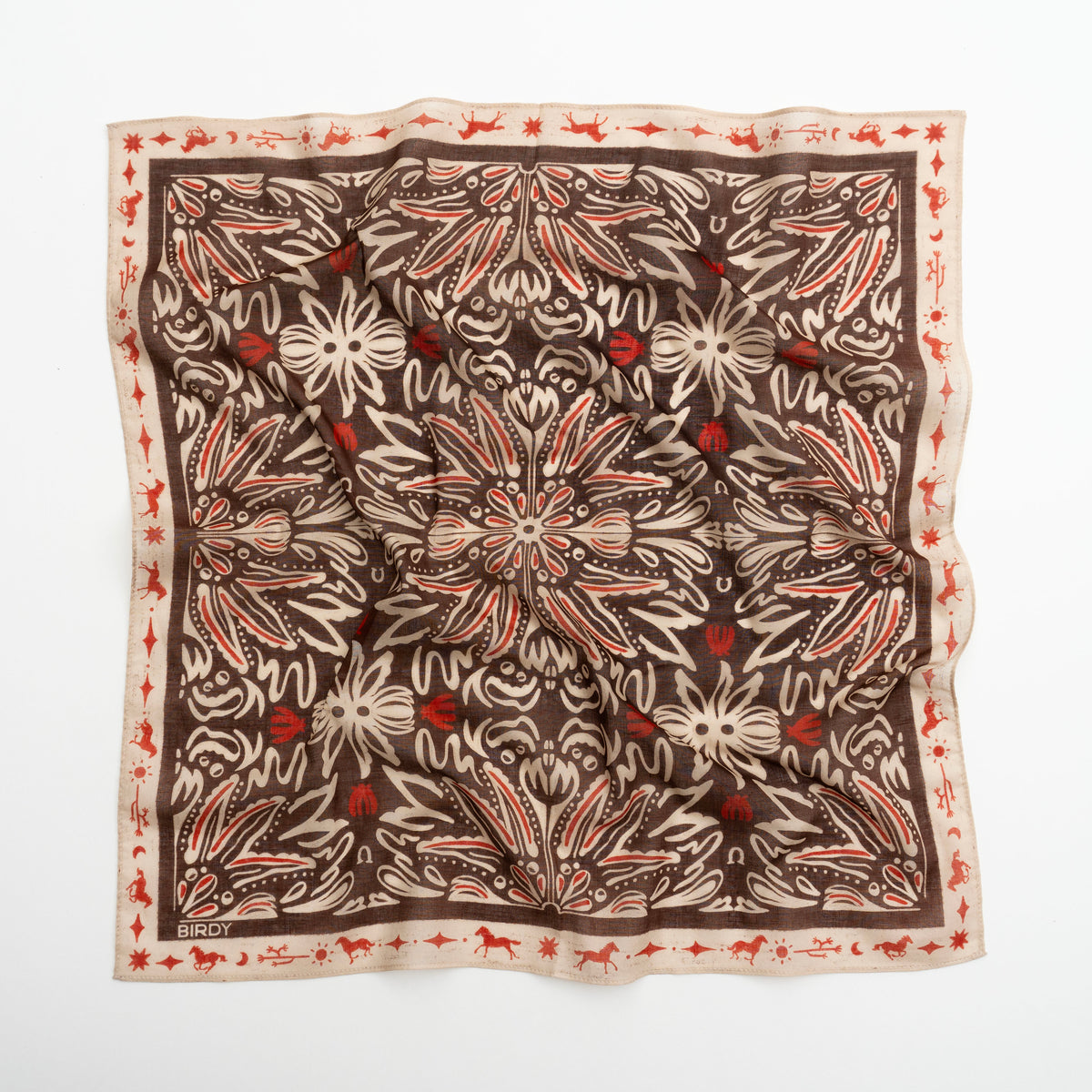 A square silk scarf with an intricate botanical and floral pattern, laid flat on a white background. The design features a dark brown center with cream-colored leafy motifs and small red floral accents, bordered by a cream edge with a red pattern.