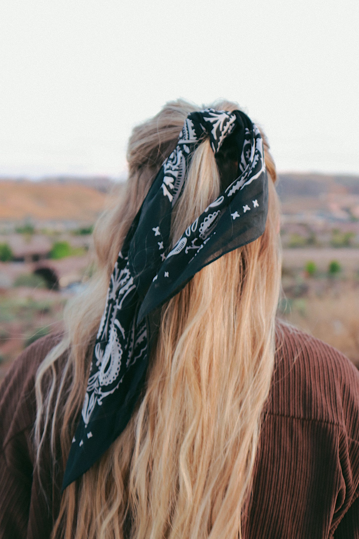 black and white owen bandana with paisley print used as a hair tie