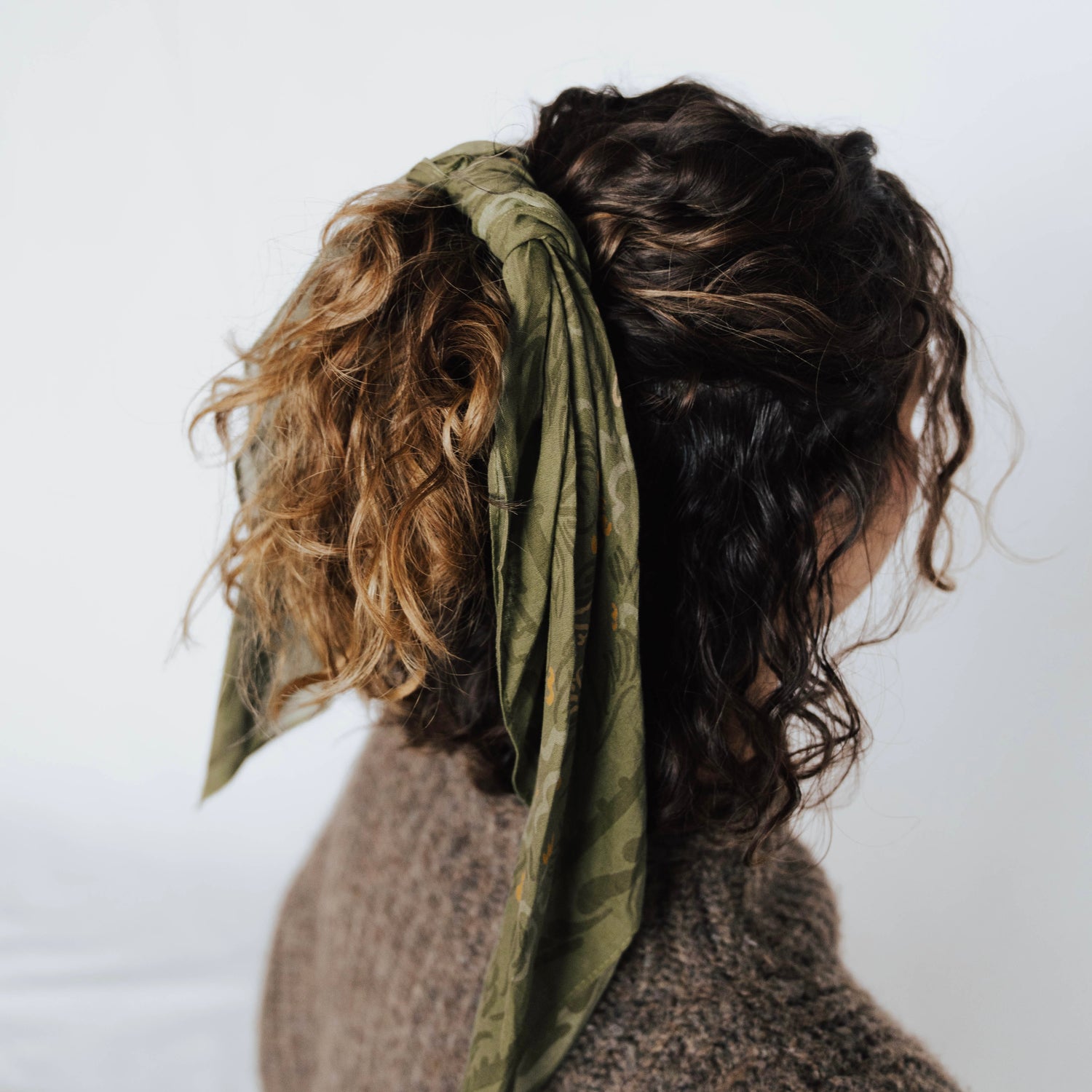 the green daphne bandana used as a scarf tied around hair for an up-do